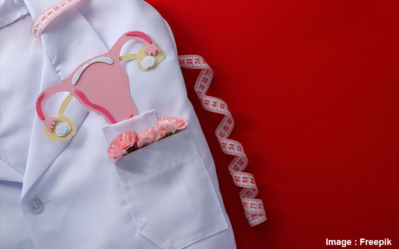 blouse médicale avec dans la poche des fleurs et l'appareil génital féminim en dessin